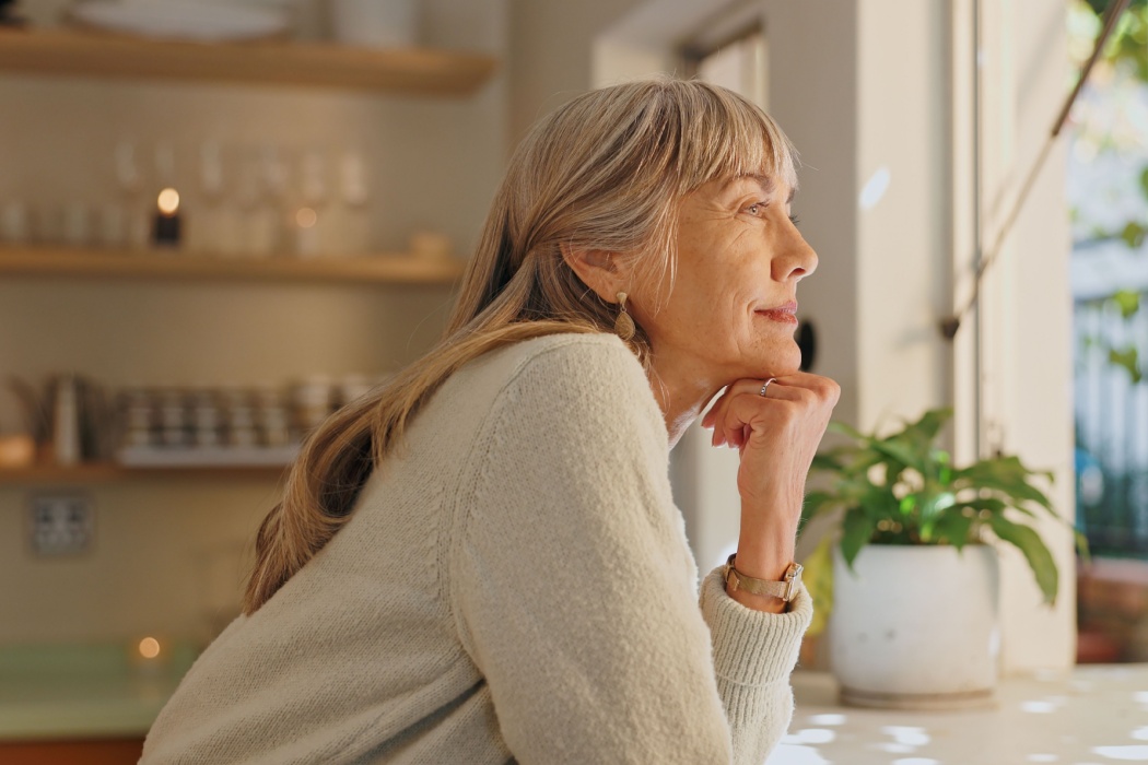 A woman looking out of the window at home.